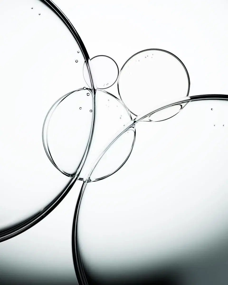 Overlapping glass bubbles resting on a pale surface, lit from behind.