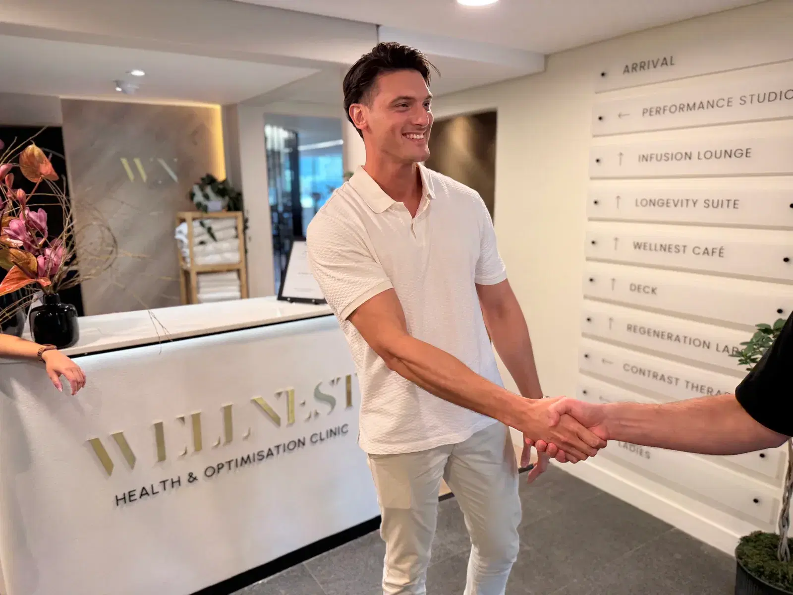 Two people shaking hands at the WellNest Gold clinic reception, Cape Town